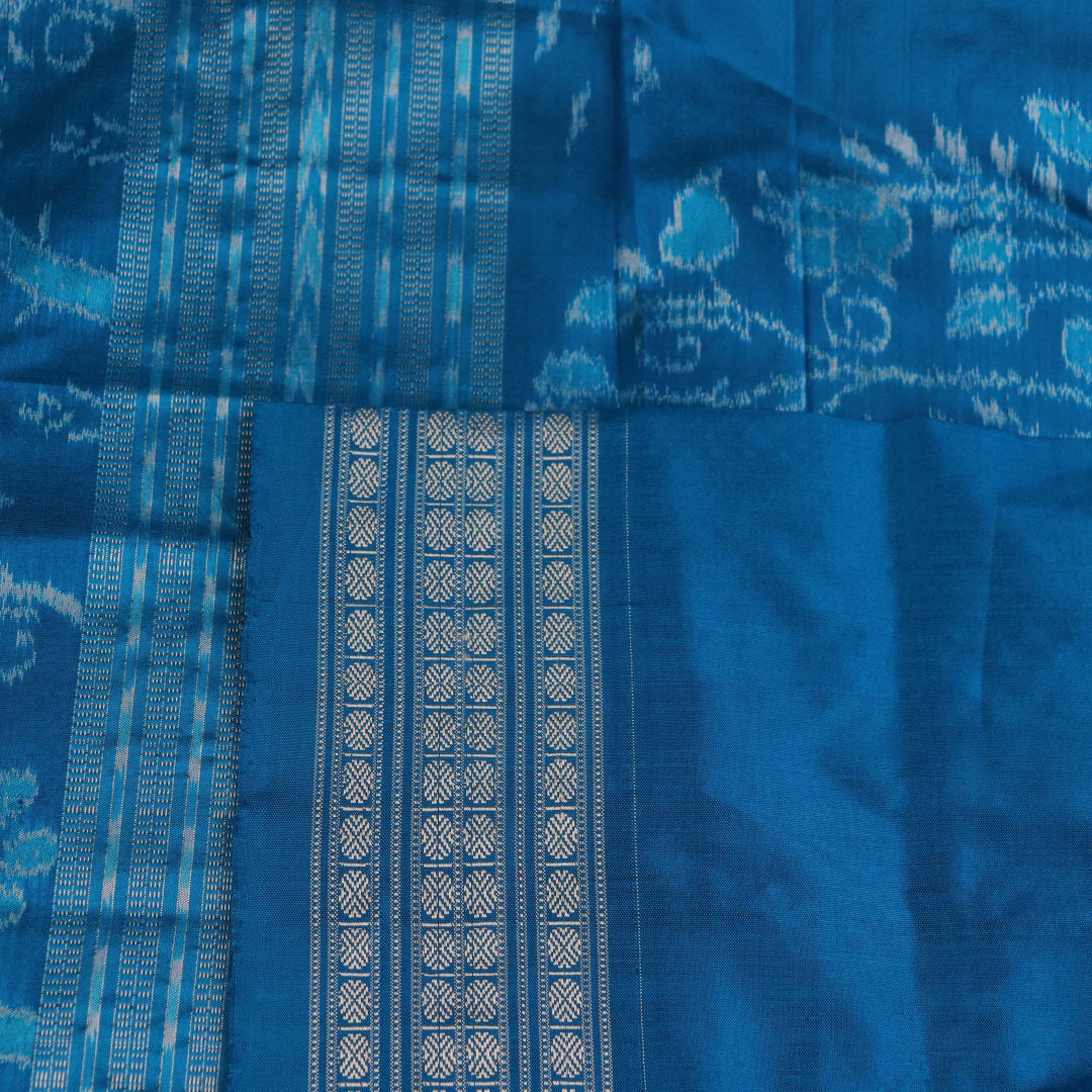 Close-up of multi-color Sambalpuri silk saree fabric showing texture and woven motifs; secondary color blue visible.