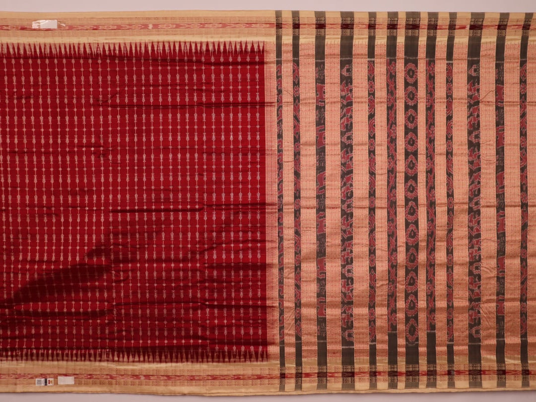 Close-up view of the richly textured silk fabric of a maroon and off-white Sambalpuri saree, featuring a delicate butta pattern.