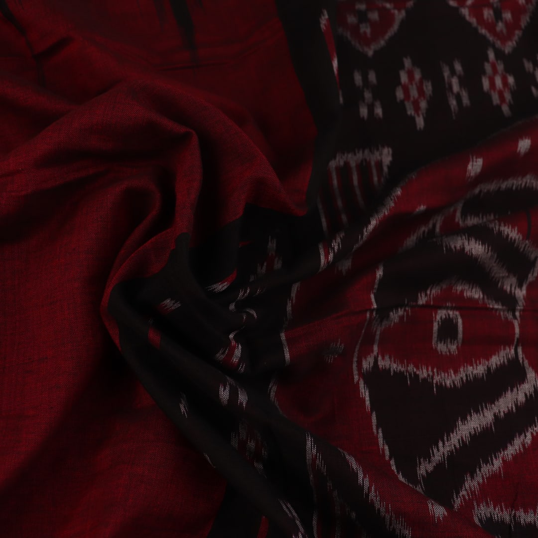 Gracefully draped maroon and black plain Sambalpuri cotton saree.