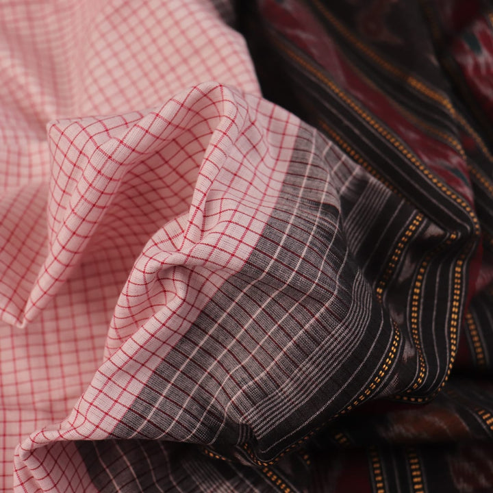 Woman draped in a white and black Sambalpuri cotton saree with motifs.