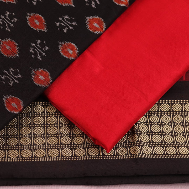 Detail of black Sambalpuri silk blouse piece from dress material, featuring red motifs.