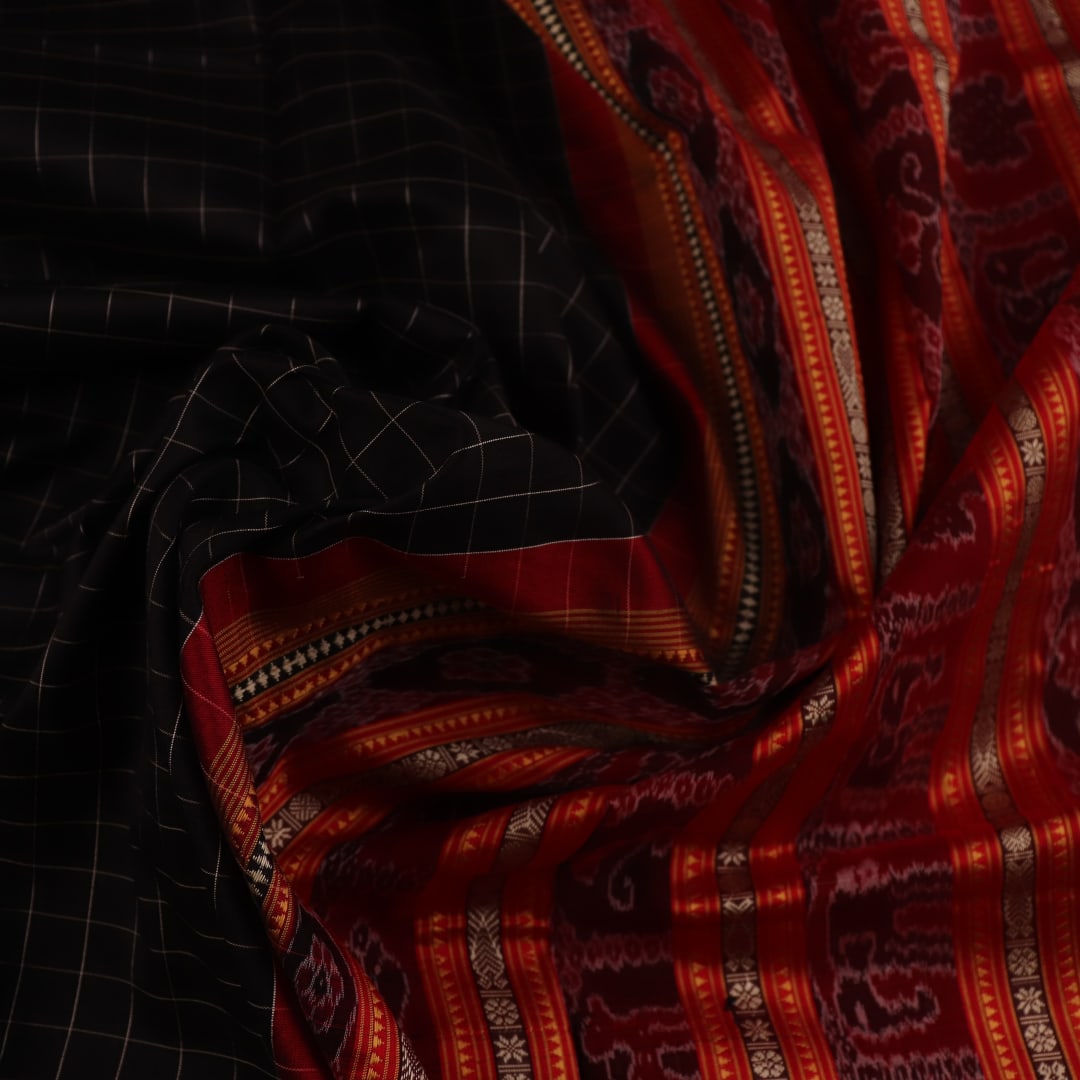 Close-up of black and red striped Sambalpuri silk saree's woven texture.
