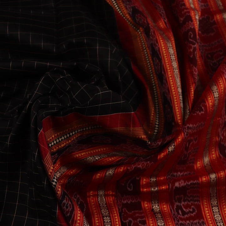 Close-up of black and red striped Sambalpuri silk saree's woven texture.