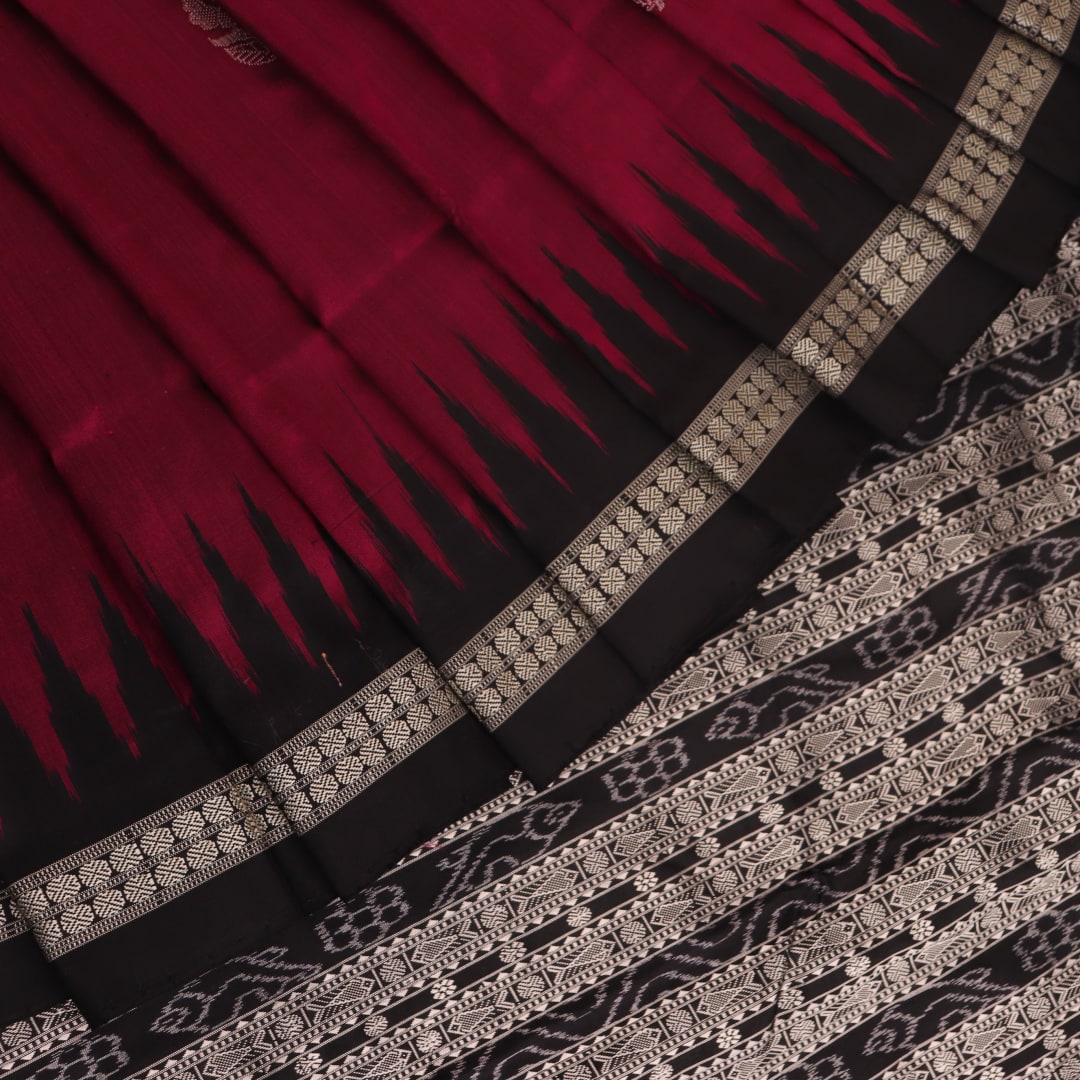 Close-up of magenta and black Bomkai silk saree texture, showing butta pattern weave.
