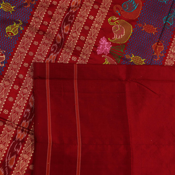 Close-up of maroon plain Sambalpuri silk saree fabric texture.