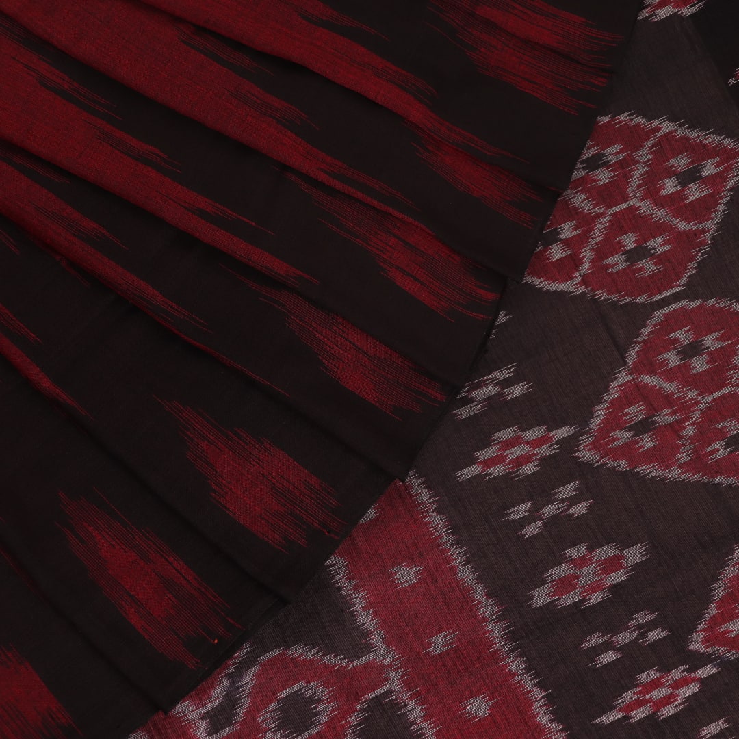 Gracefully draped maroon and black plain Sambalpuri cotton saree.