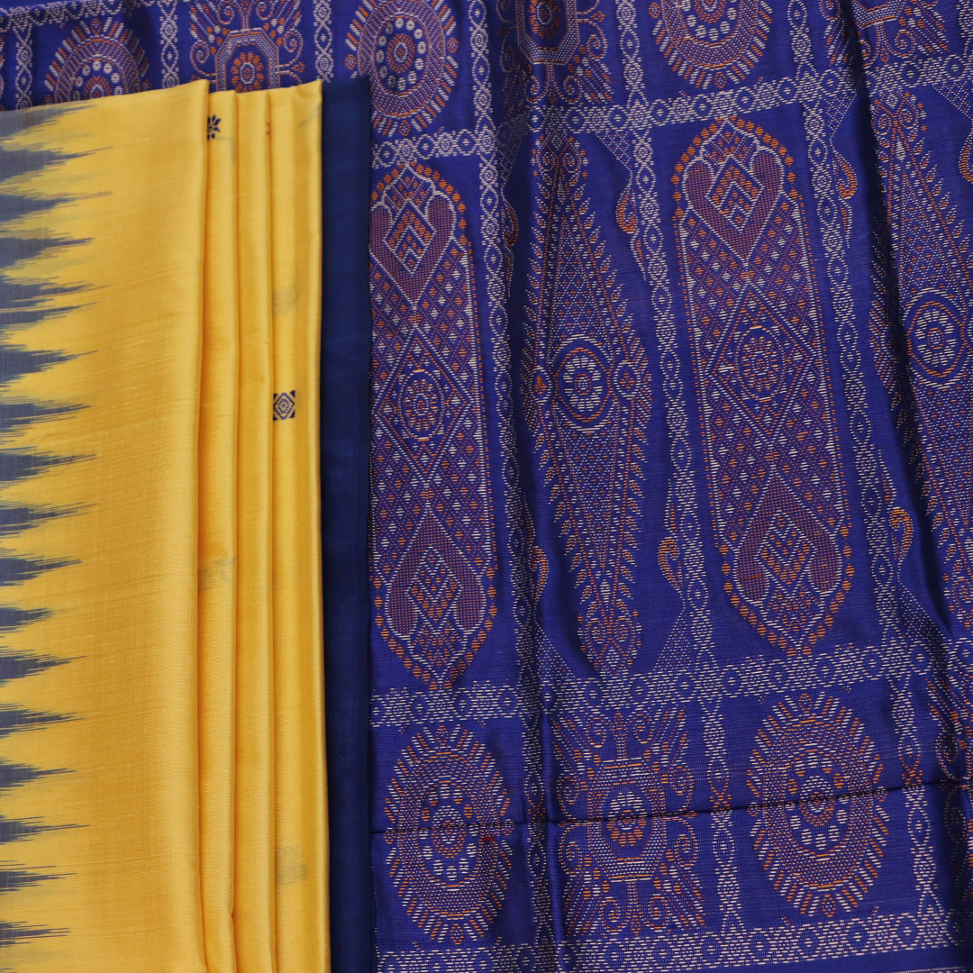 Textured close-up of yellow Bomkai silk saree fabric with blue butta pattern.