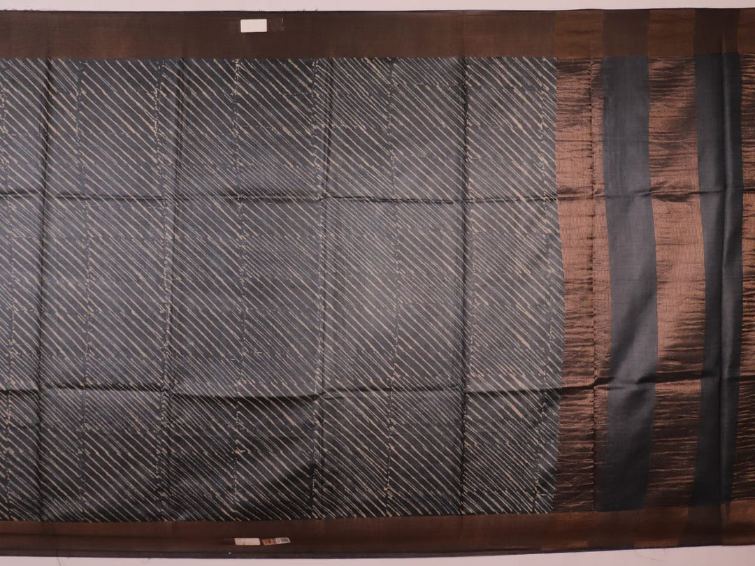 Close-up of the natural slub texture of grey printed Tussar silk saree fabric.