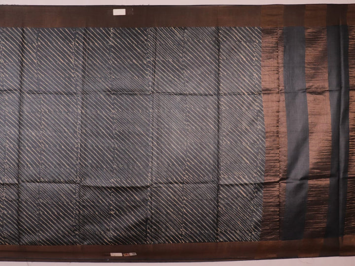 Close-up of the natural slub texture of grey printed Tussar silk saree fabric.