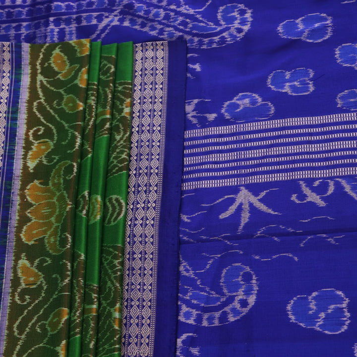 Close-up of green and blue Sambalpuri silk saree fabric showing intricate handloom weave and motif details.