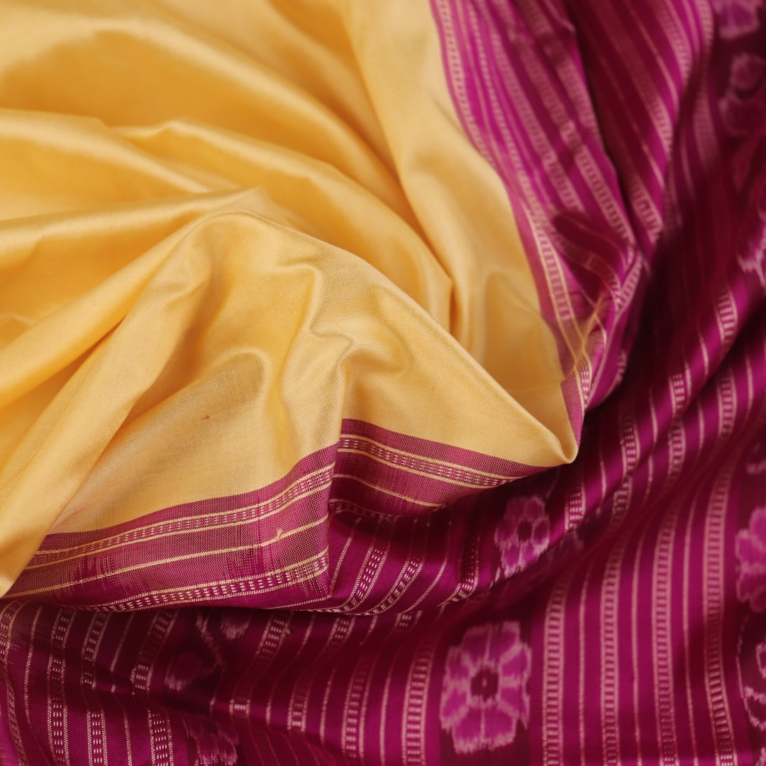 Close-up of plain cream and magenta Sambalpuri Silk Saree fabric texture.