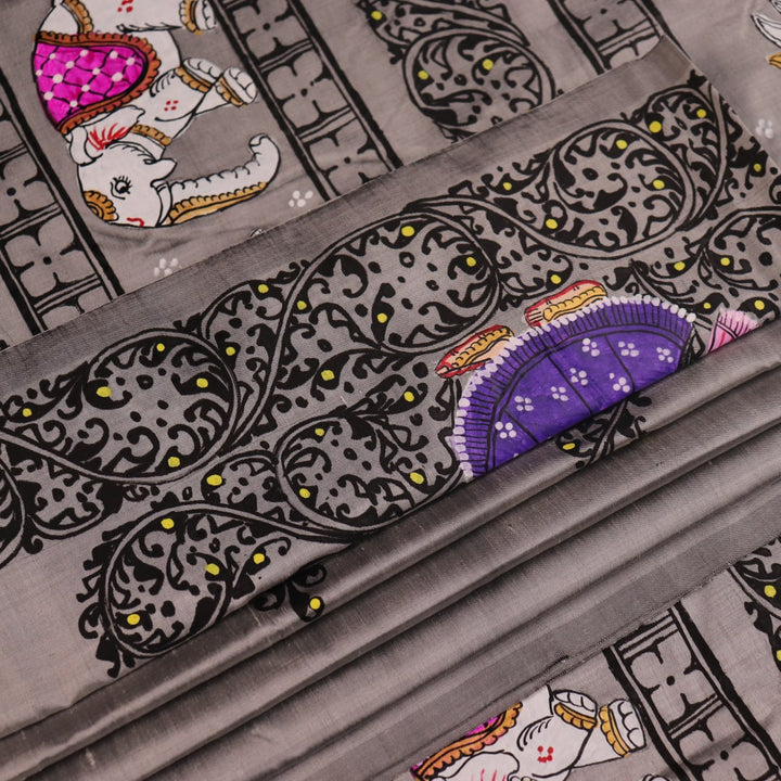 Close-up of grey silk Patachitra saree fabric showing hand-painted texture and intricate weave detail.