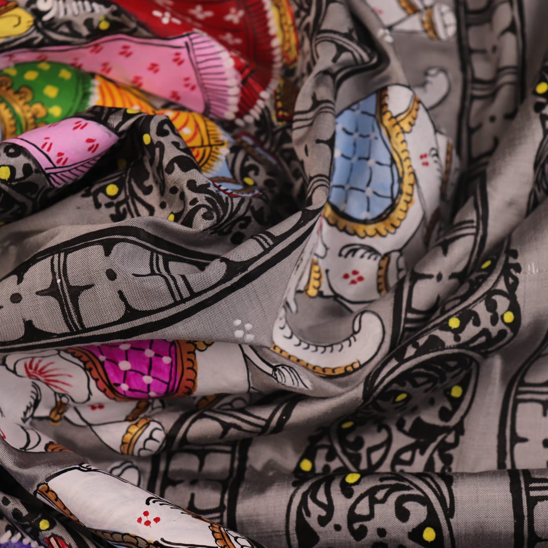 Close-up of grey silk Patachitra saree fabric showing hand-painted texture and intricate weave detail.