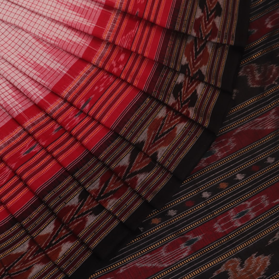 Woman draped in a white and black Sambalpuri cotton saree with motifs.