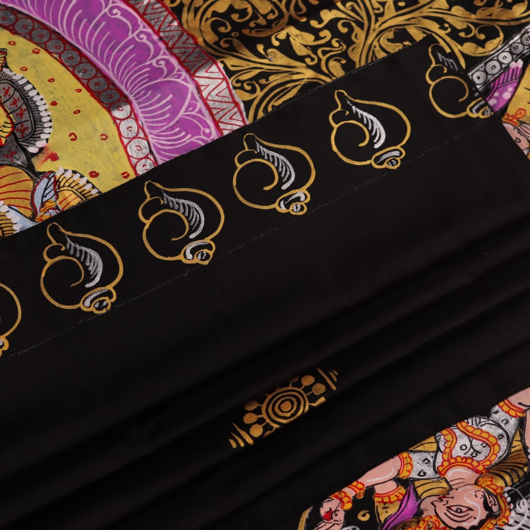 Close-up of black silk Patachitra saree fabric, showcasing hand-painted texture and detail.