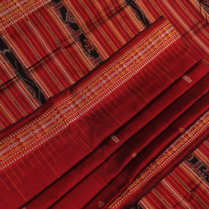Close-up of maroon Sambalpuri Silk Saree fabric, showing intricate butta weave texture.