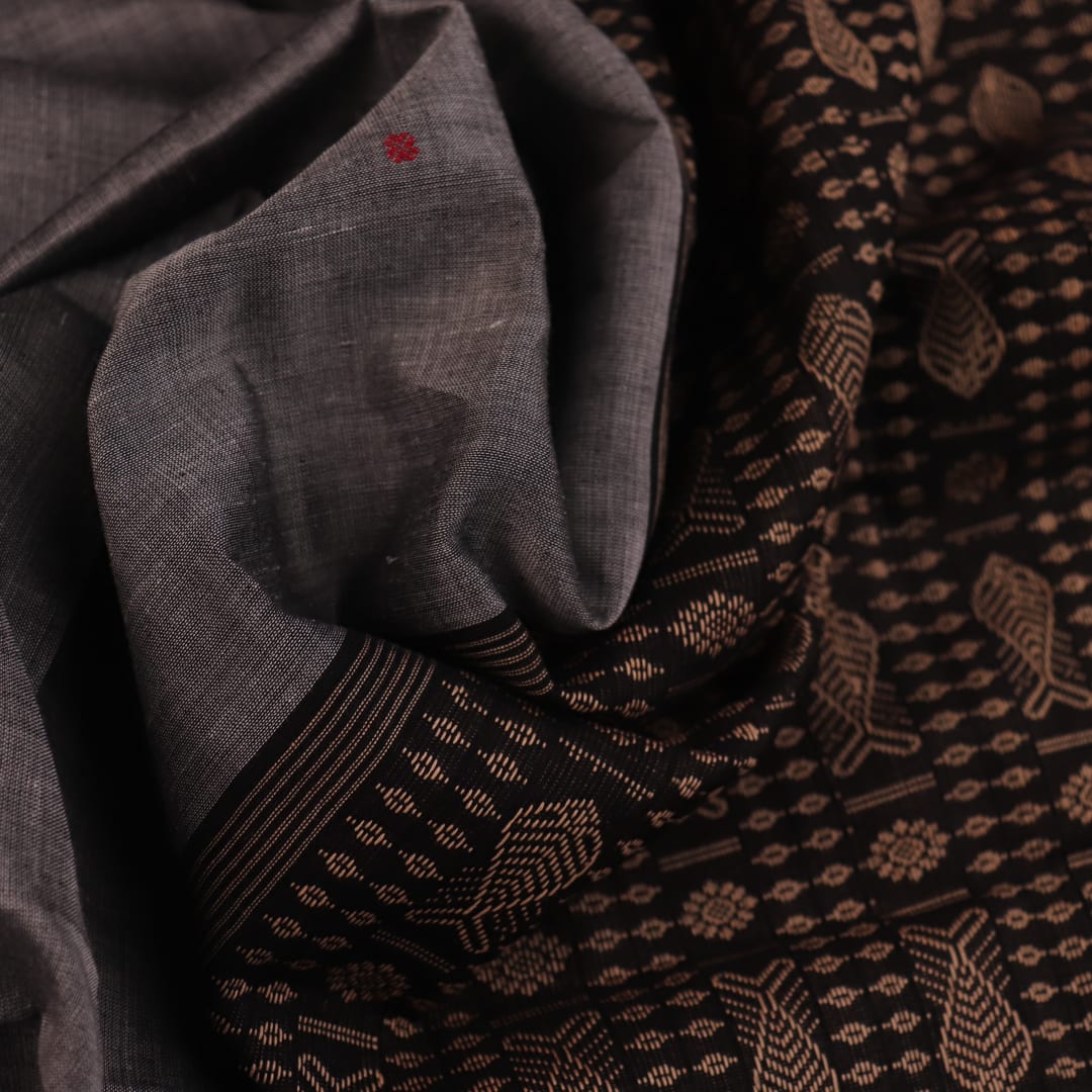 Full view of grey Bomkai cotton saree, featuring black border and butta pattern.