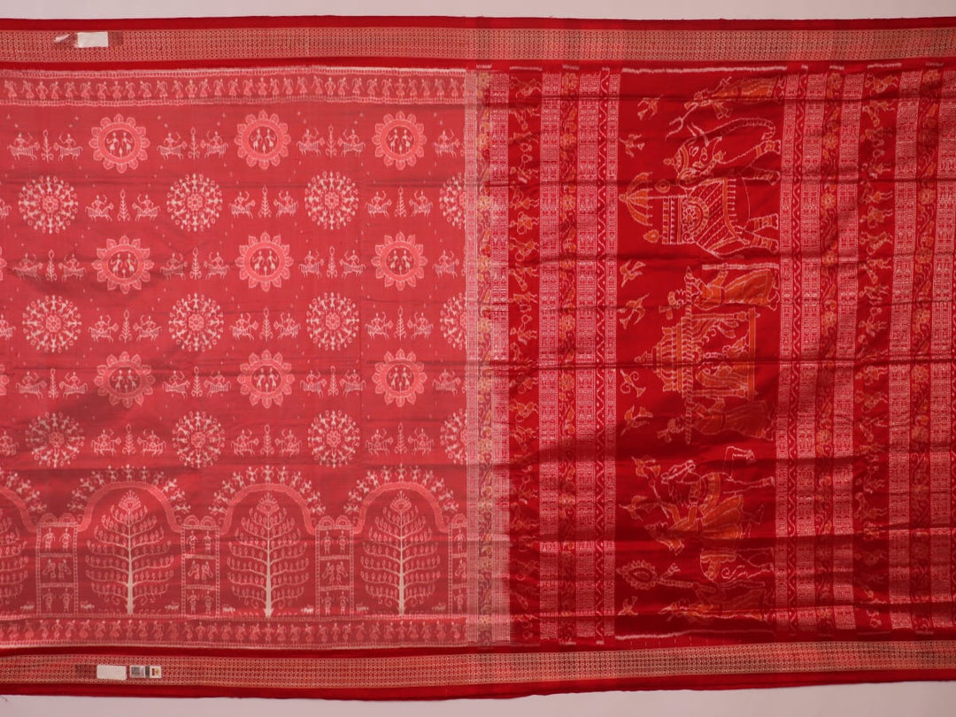 Close-up of a peach and red Sambalpuri silk saree fabric showing the intricate handloom texture and motifs.