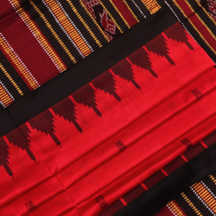 Textured close-up of red and black Sambalpuri Silk Saree fabric, highlighting the woven butta pattern.