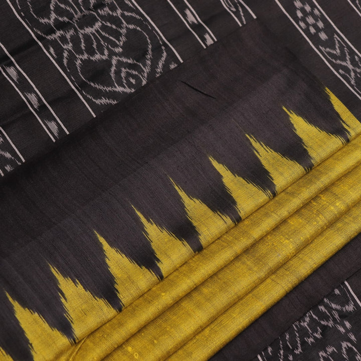 Close-up of the plain, slubby texture of a handwoven green and black Tussar silk saree.