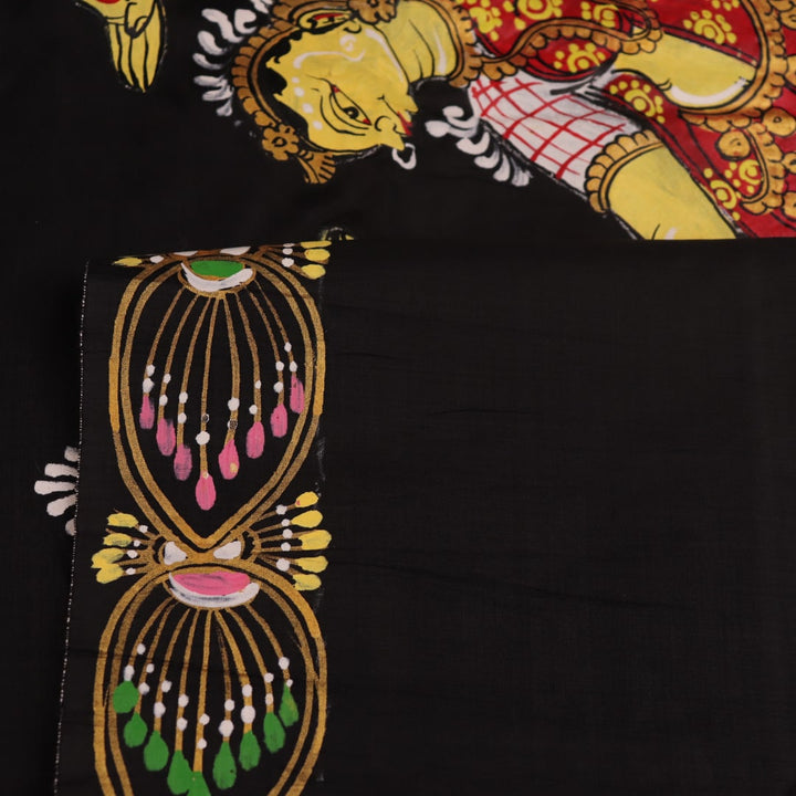 Close-up of black silk Patachitra saree fabric texture showing hand-painted details.