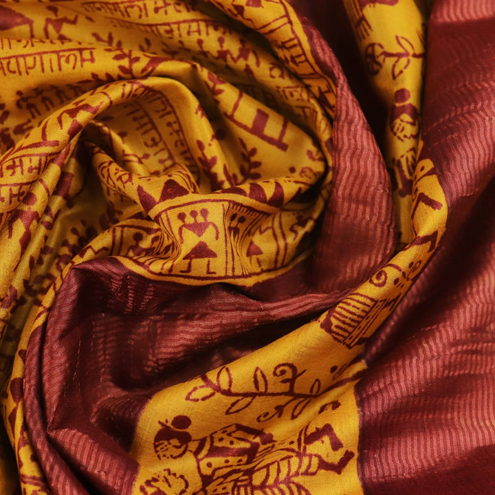 Close-up showing the textured weave of a yellow and brown printed Tussar silk saree.