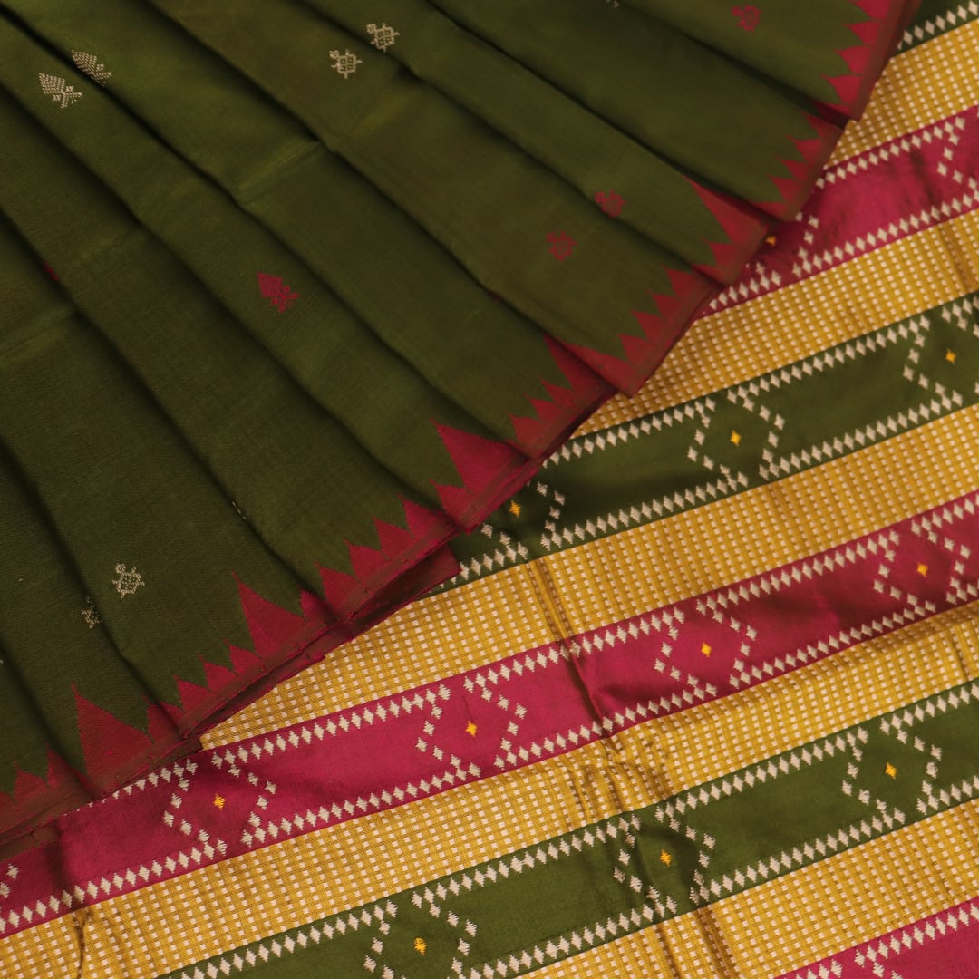 Close-up of the textured green Sambalpuri Silk Saree fabric, highlighting the woven butta pattern.