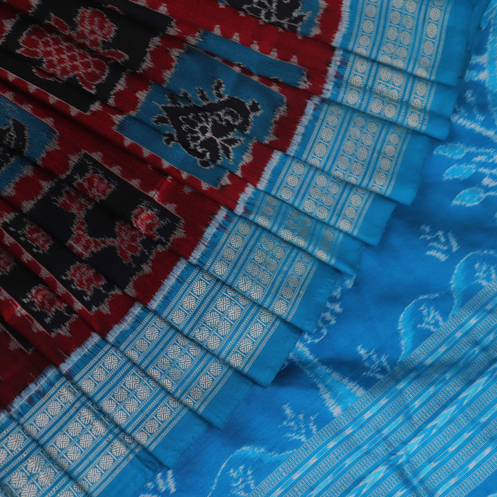 Close-up of black Sambalpuri silk saree fabric texture, showcasing the weave and subtle motif details.
