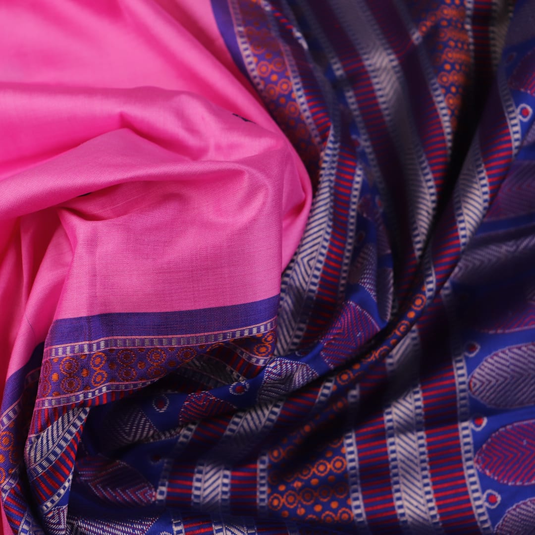 Close-up of pink and blue Dongria Silk Saree fabric texture with butta pattern.