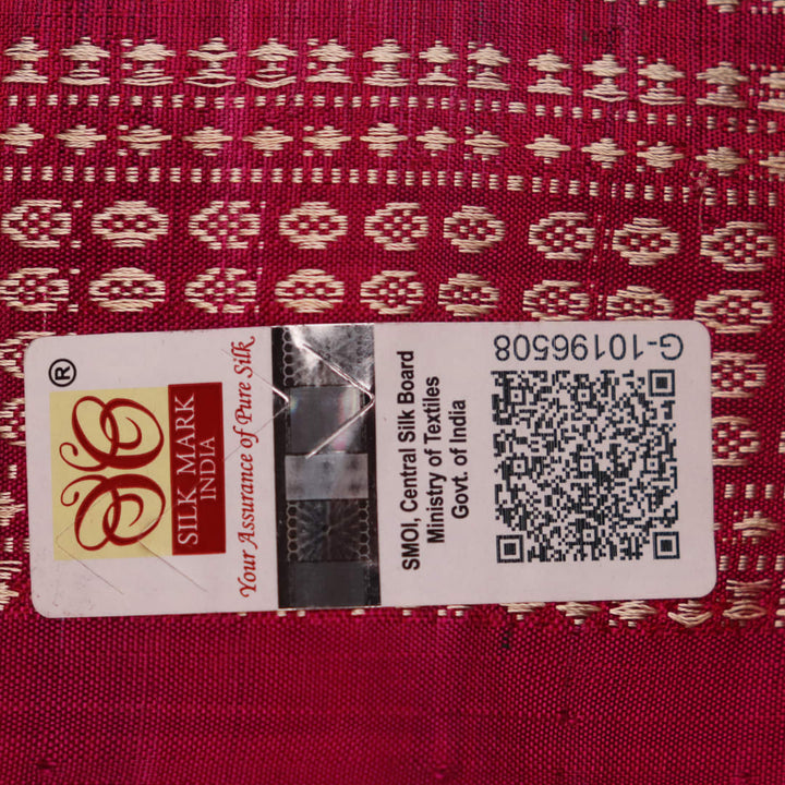 Close-up of textured green Sambalpuri silk saree fabric with magenta motifs.