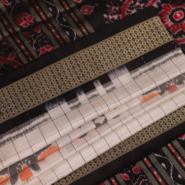 Close-up of handloom Sambalpuri silk saree fabric texture; white with subtle black motifs.