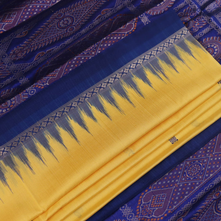 Textured close-up of yellow Bomkai silk saree fabric with blue butta pattern.