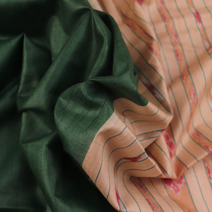 Close-up of the green and off-white plain Tussar silk saree, highlighting its natural slub texture.