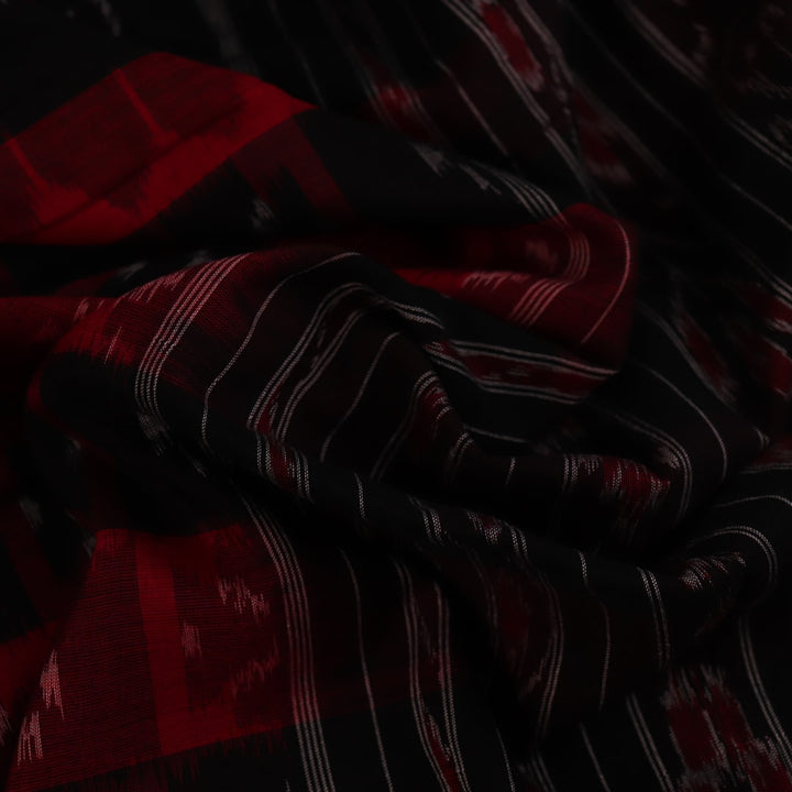Red and black Sambalpuri cotton saree draped, showcasing overall styling and motifs.