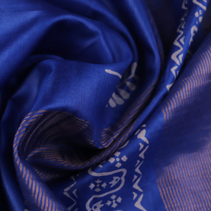 Close-up of blue printed Tussar silk handloom saree fabric texture.