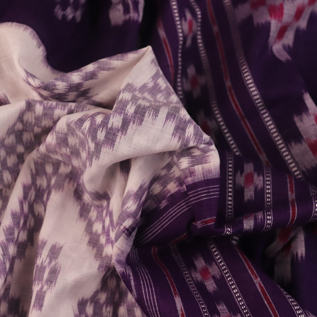 Elegantly draped red and violet Sambalpuri cotton saree with traditional motifs.