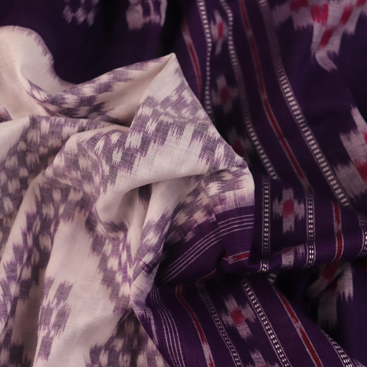 Elegantly draped red and violet Sambalpuri cotton saree with traditional motifs.