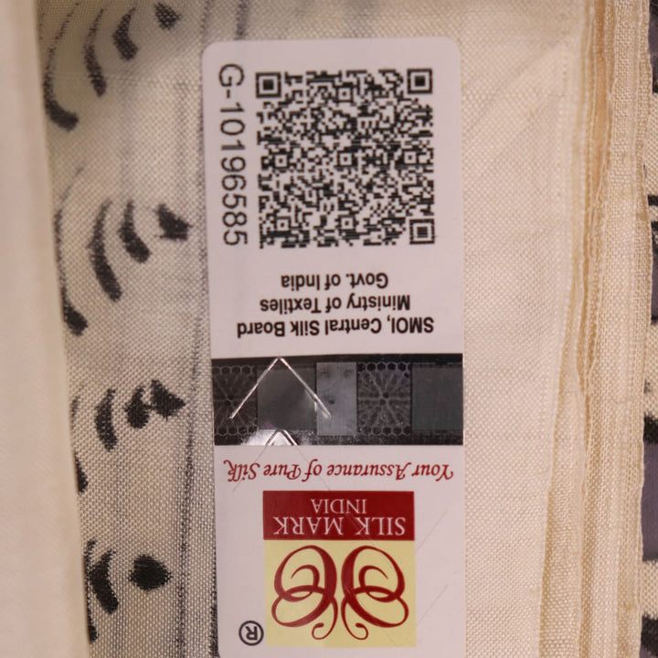 Close-up of the white silk saree fabric texture, showcasing the handloom weave and painted Patachitra details.