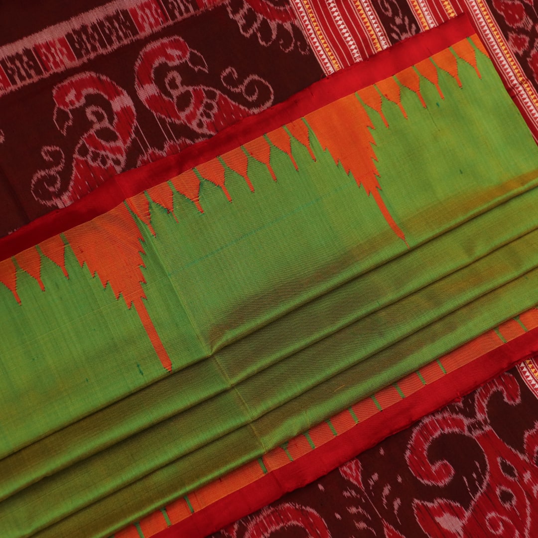 Close-up of plain green Sambalpuri silk saree fabric texture.