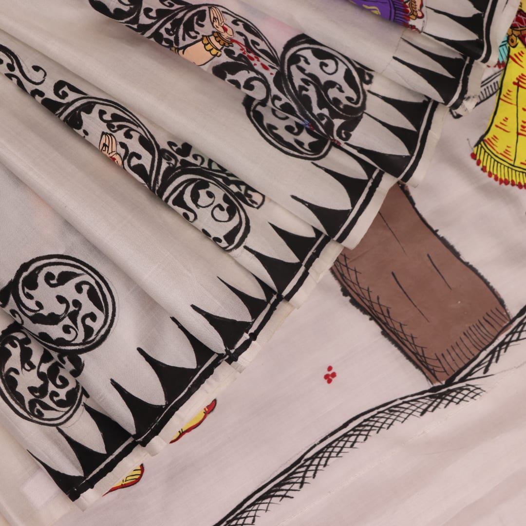 Close-up of white silk Patachitra saree fabric showing hand-painted texture and detail.