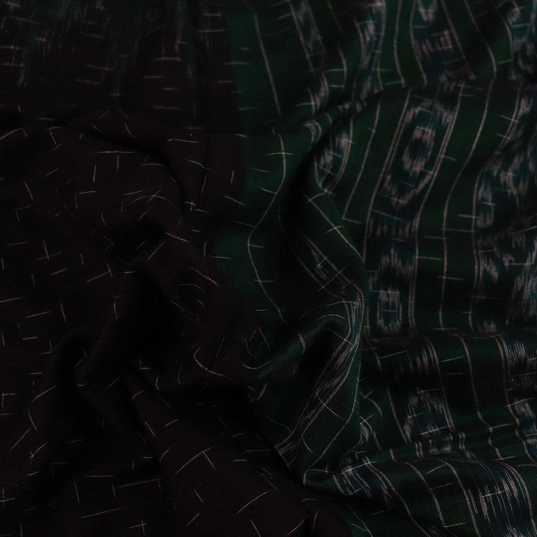 Black and green plain Sambalpuri cotton saree, gracefully draped.