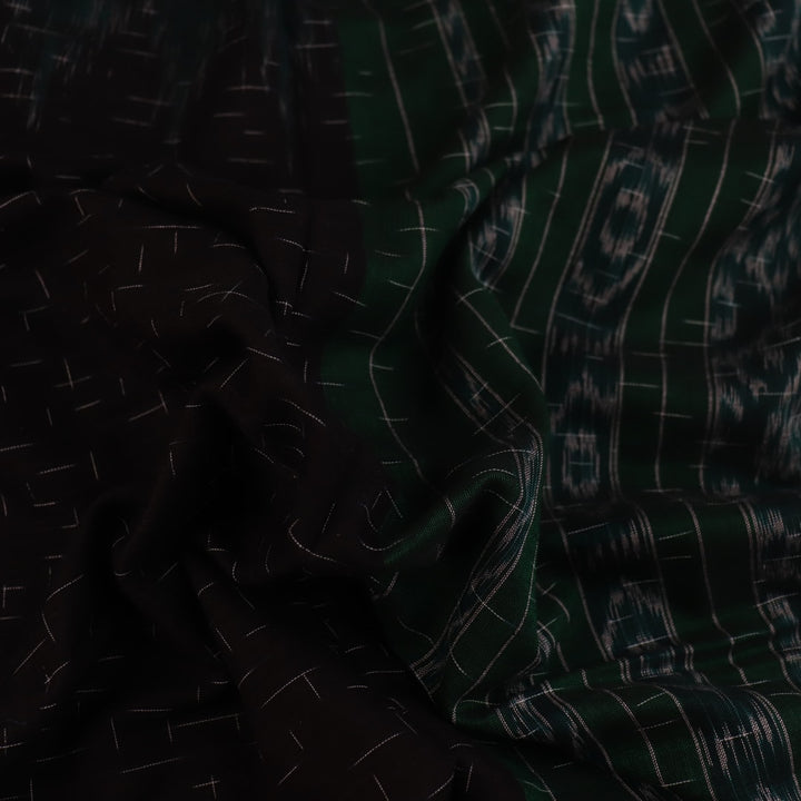 Black and green plain Sambalpuri cotton saree, gracefully draped.