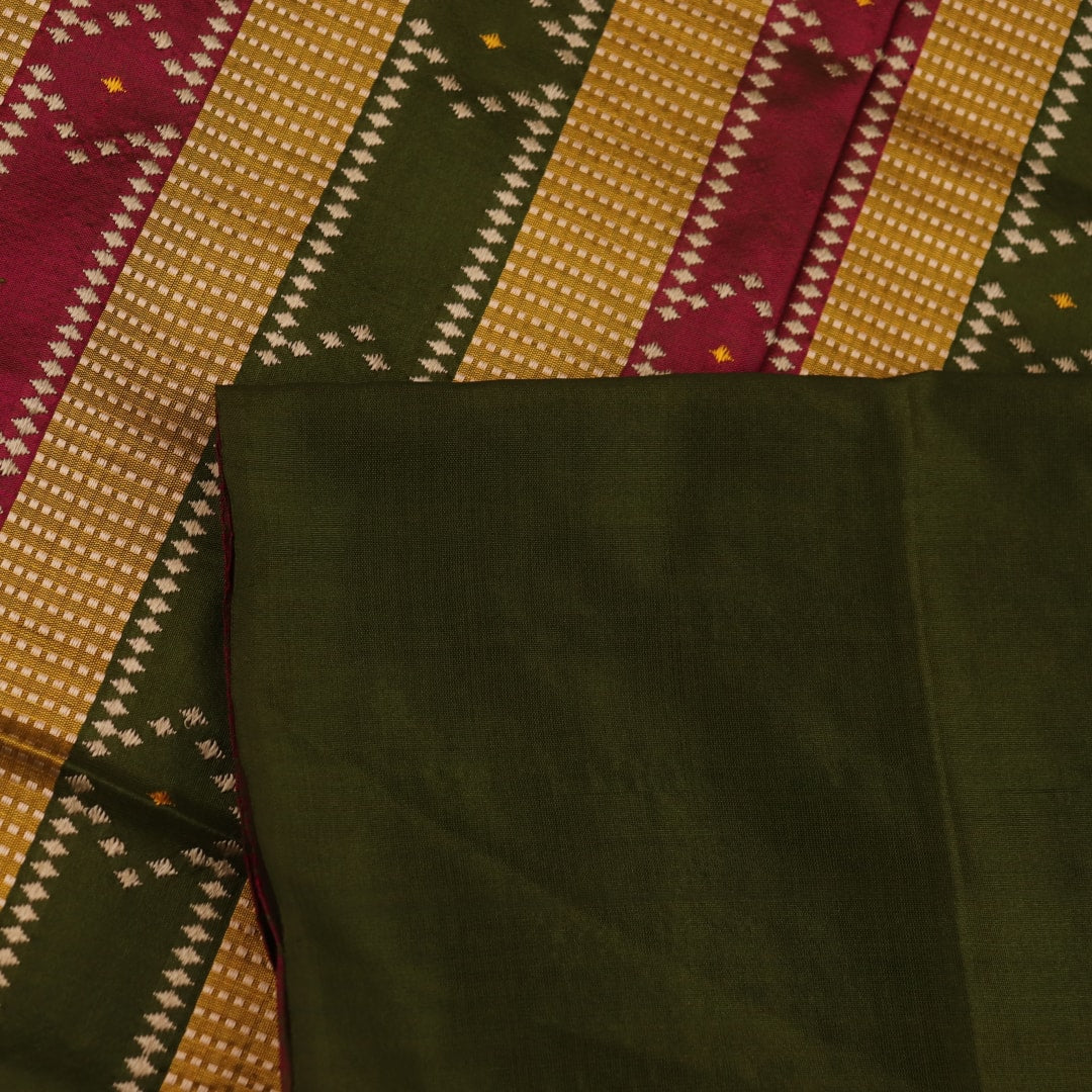 Close-up of the textured green Sambalpuri Silk Saree fabric, highlighting the woven butta pattern.