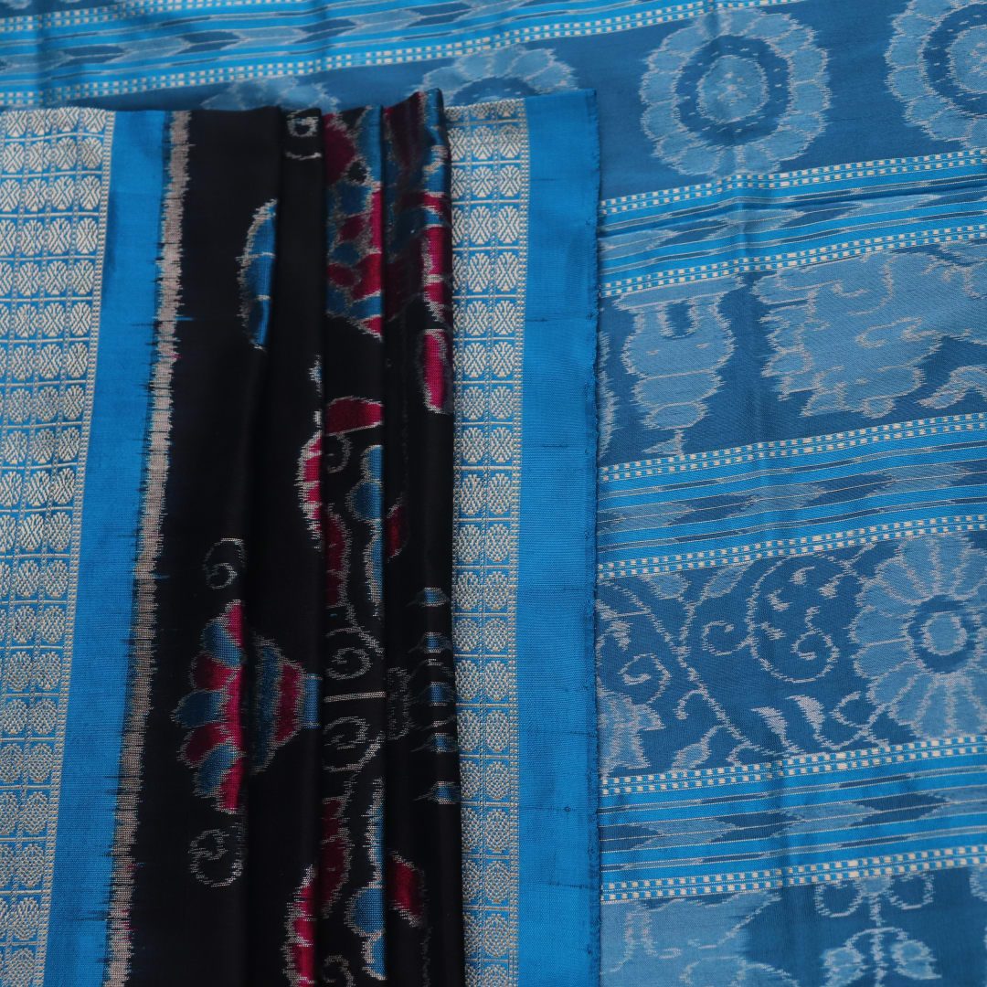 Close-up of black Sambalpuri silk saree fabric texture, showcasing the weave and subtle motif details.