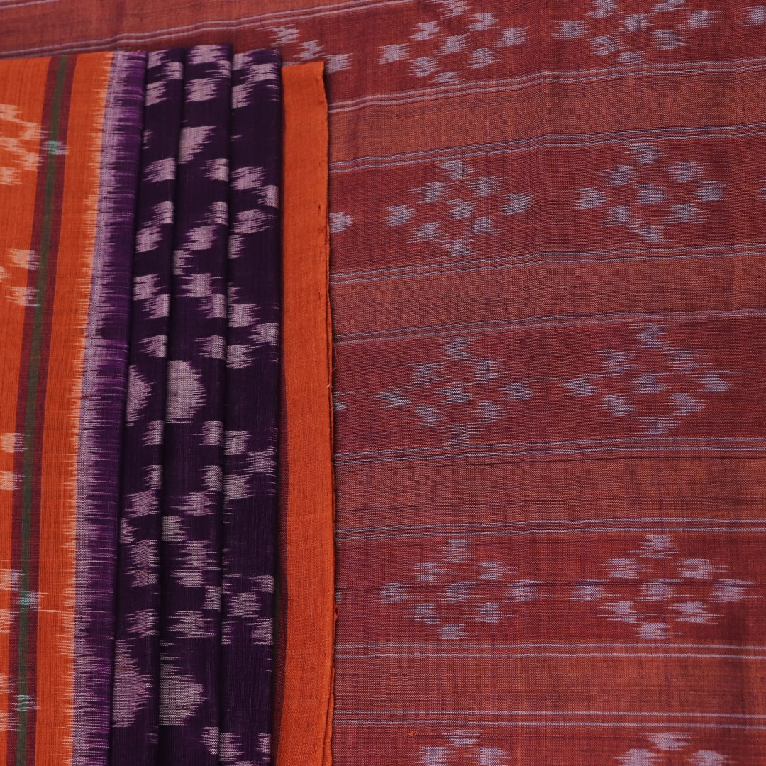 Violet & rust Sambalpuri cotton saree with motifs, elegantly draped.