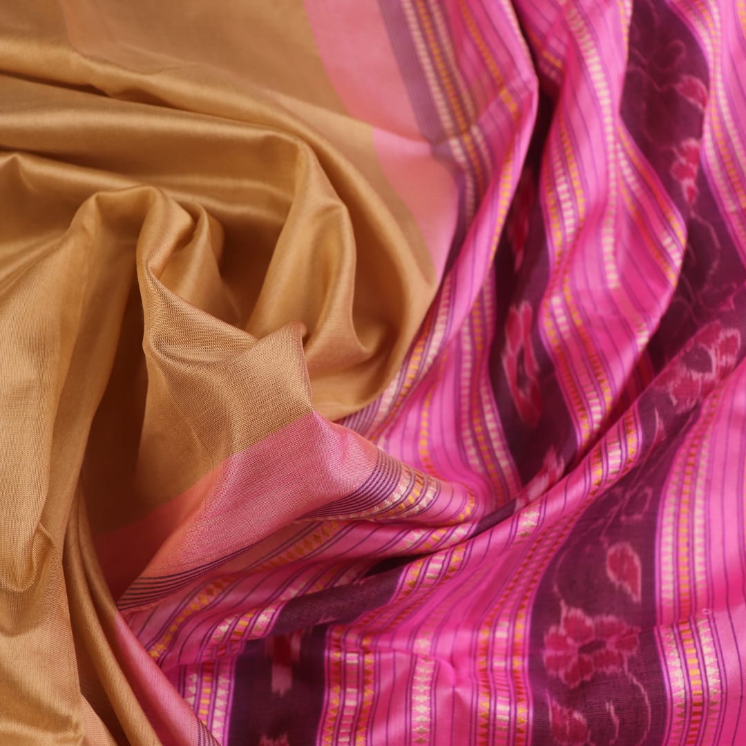 Close-up of green and pink plain Sambalpuri silk saree fabric texture.