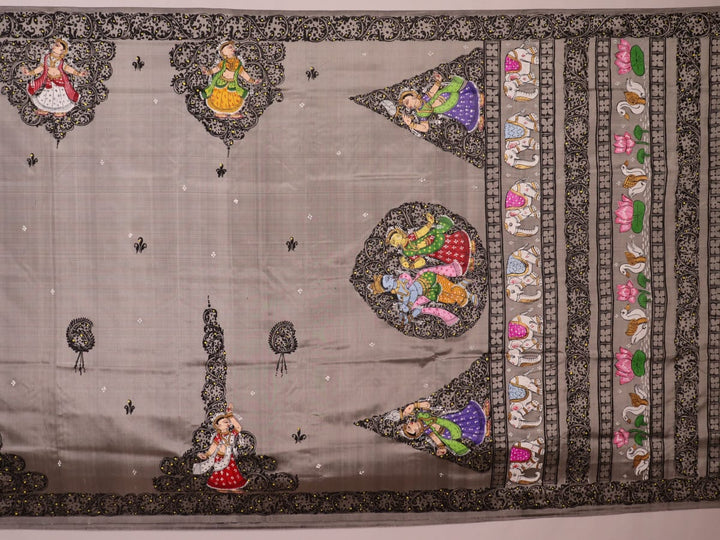 Close-up of grey silk Patachitra saree fabric showing hand-painted texture and intricate weave detail.