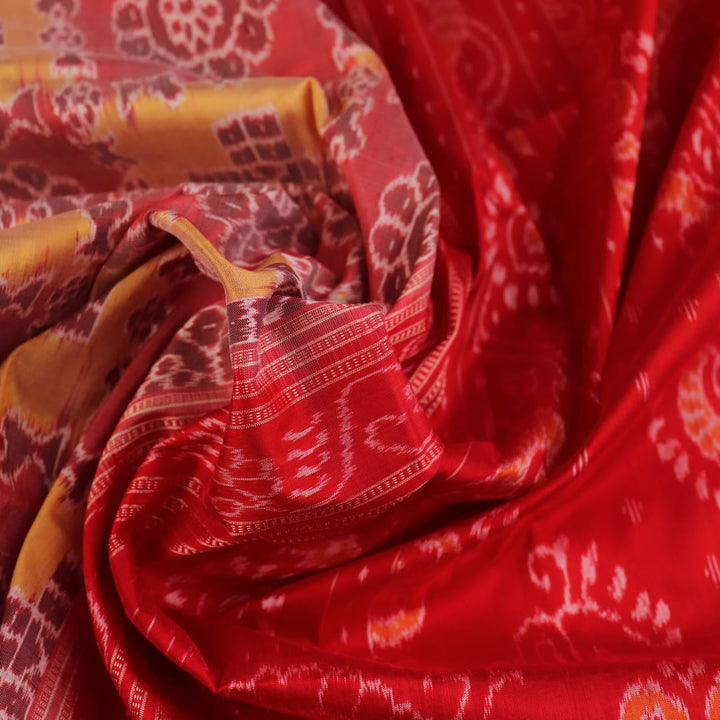 Close-up of multicolored silk Sambalpuri saree fabric showing intricate handloom weave texture.