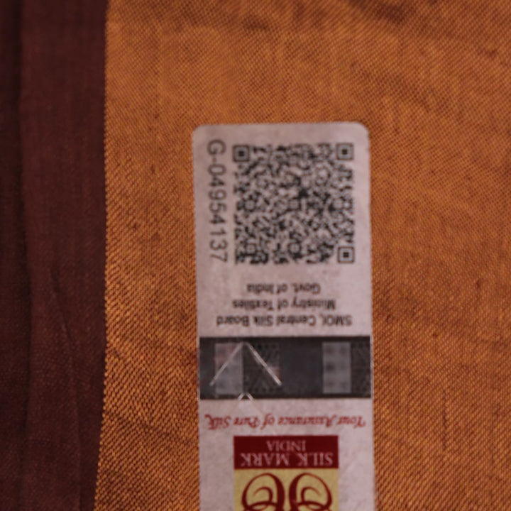 Close-up of the brown Tussar silk saree fabric, highlighting its natural slub texture and printed pattern.