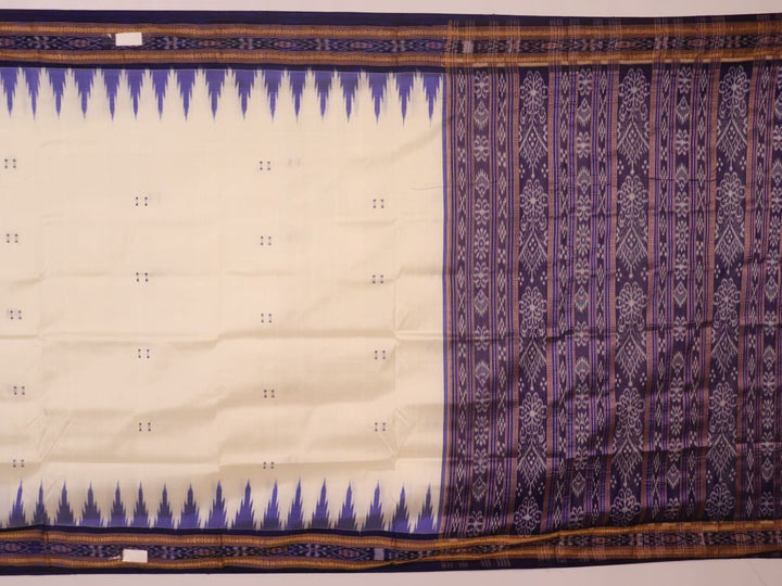 Woman elegantly draped in a white and blue Khandua silk saree with butta pattern.